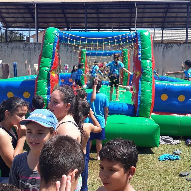 Crianças diante de um inflável no pátio do colégio