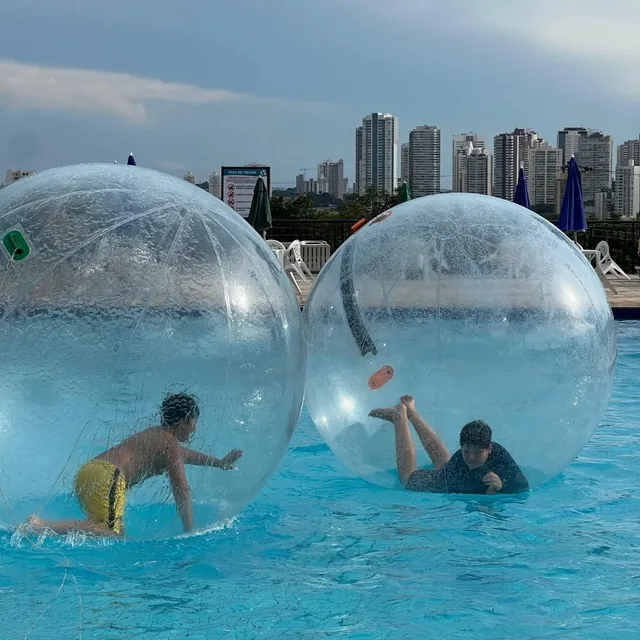 Duas crianças dentro de bolas aquáticas transparentes na piscina