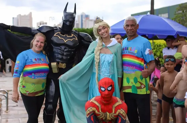Batman, Elsa, Homem-Aranha e a equipe com crianças no Dia das Crianças