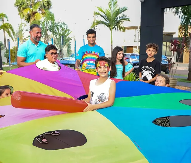 Crianças e monitores com um paraquedas colorido